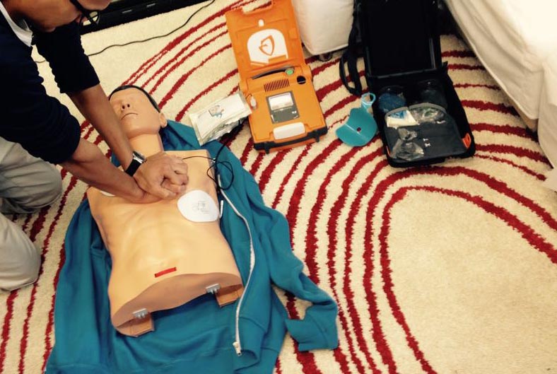 Image d'une personne utilisant un défibrillateur sur un mannequin.